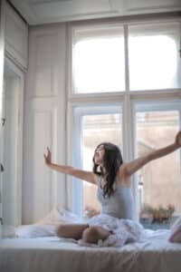 A woman stretching in bed
