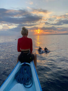 Woman sitting on a boat while watching the sunset