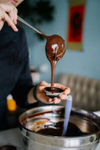 A woman pouring chocolate in a Mold