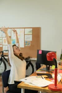 A woman stretching at her desk