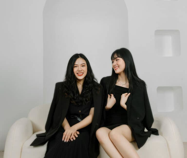 Two women sitting on a couch.