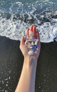 A woman holding a handful of seashells