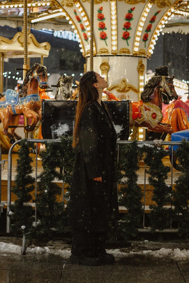 A woman standing in front of a merry-go-round