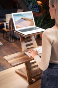 A woman using a standing desk whilst doing her work