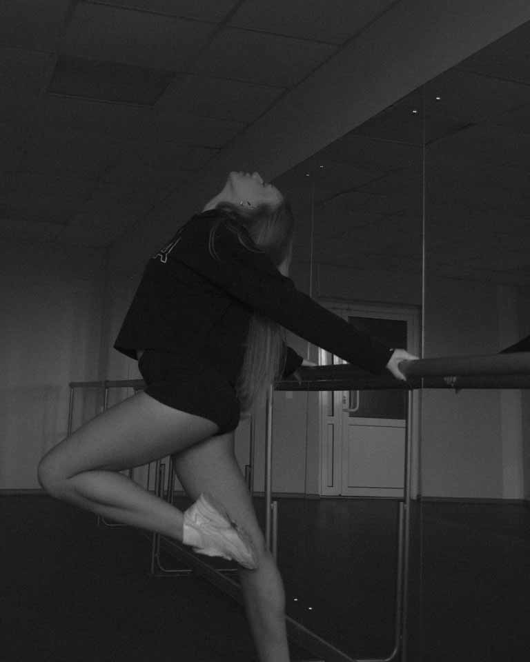 A woman practicing barre in a dance studio
