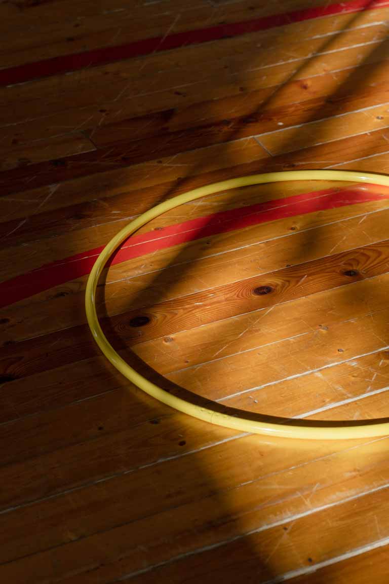 A yellow hula hoop laying on the ground
