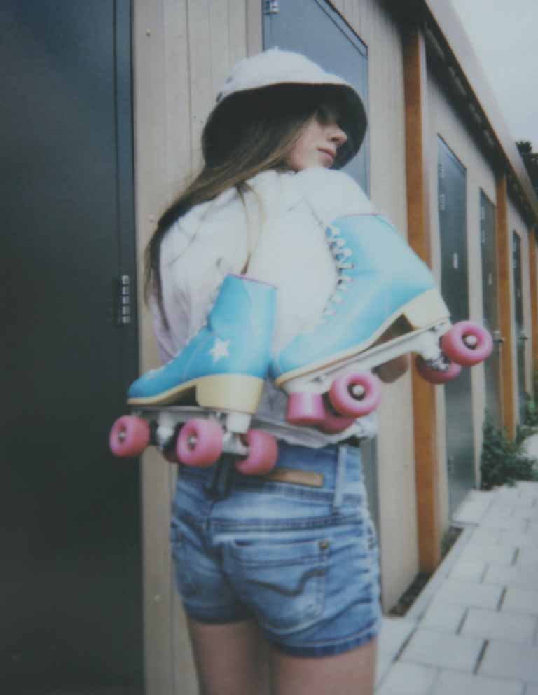 A woman carrying roller blades on her shoulders