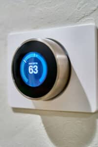 Blue thermostat mounted against a white wall