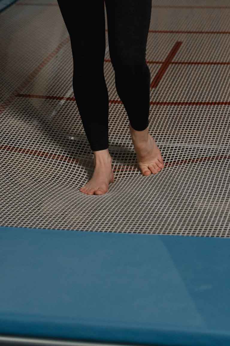A cropped woman's legs standing on a trampoline