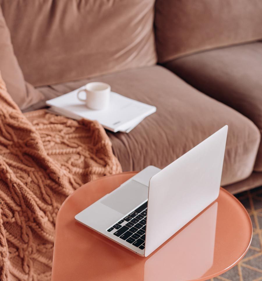 laptop placed on top of an orange glass surface in a cozy lounge room